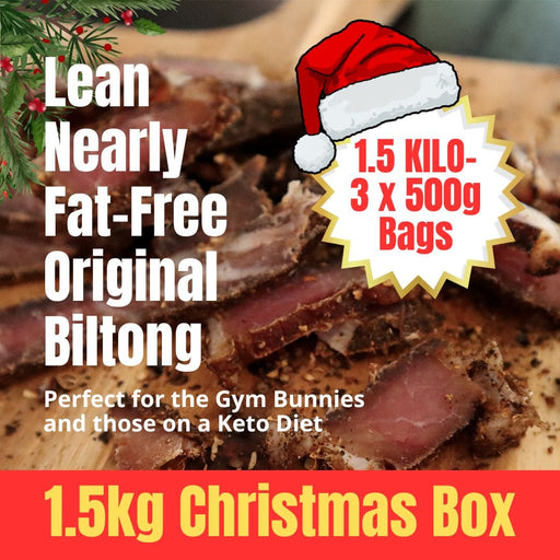 Biltong Christmas Boxes with a Santa hat and Christmas-themed text on a wooden surface