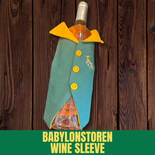 Wine bottle wrapped in a decorative sleeve with buttons and a design, on a wooden background. Brand 'Babylonstoren' visible.