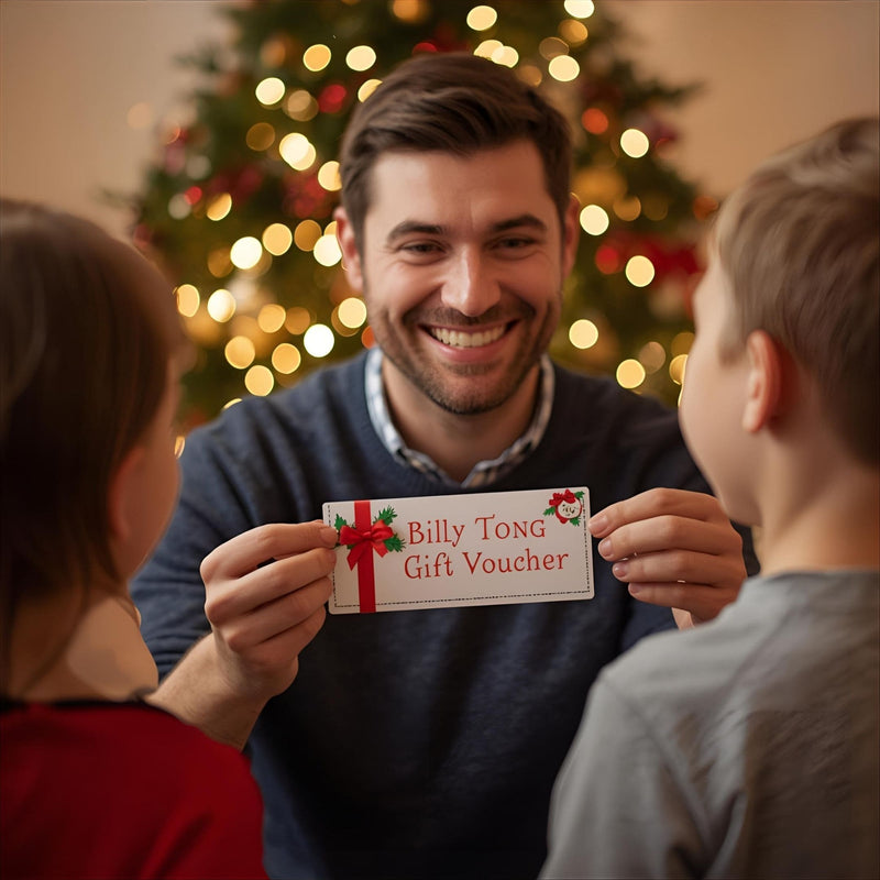 Man holding up a Billy Tong Gift Voucher in front of a Christmas Tree