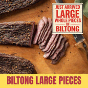 Large whole pieces of biltong, sliced on a wooden board with text indicating 'Just Arrived Large Whole Pieces of Biltong'.
