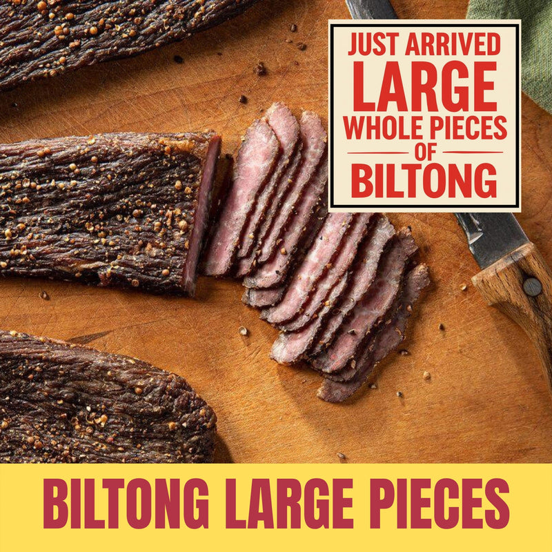 Large whole pieces of biltong, sliced on a wooden board with text indicating 'Just Arrived Large Whole Pieces of Biltong'.