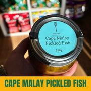 Jar of Cape Malay Pickled Fish held in a hand with a blurred store background