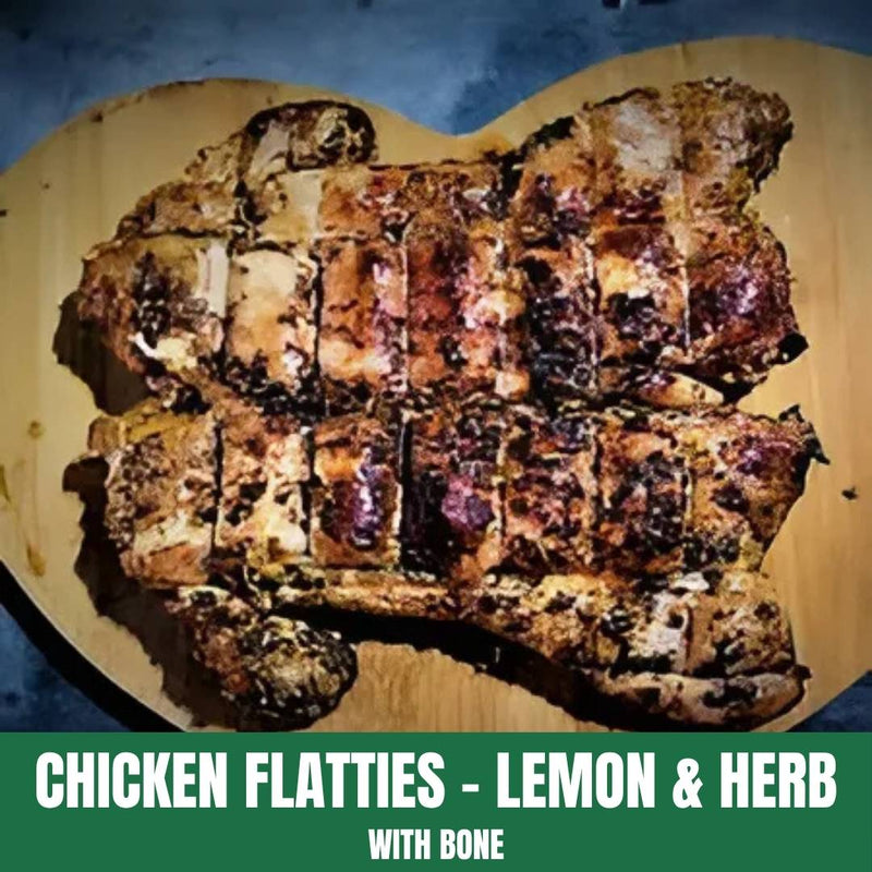 Grilled chicken flatties with lemon and herb seasoning on a wooden cutting board.