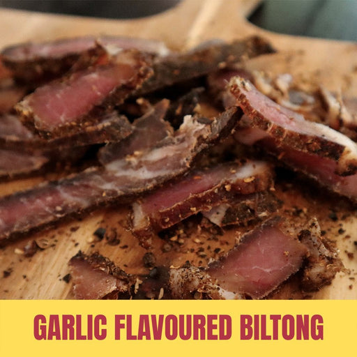 Sliced garlic flavoured biltong on a wooden board with text overlay.