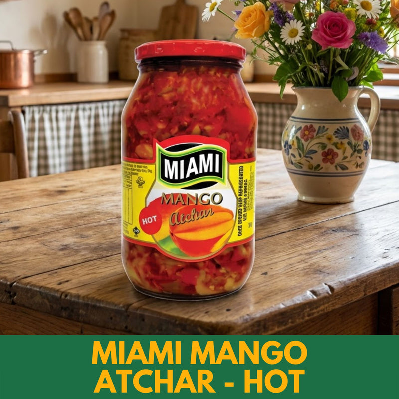 Jar of Miami Mango Atchar on a wooden table with flowers in the background