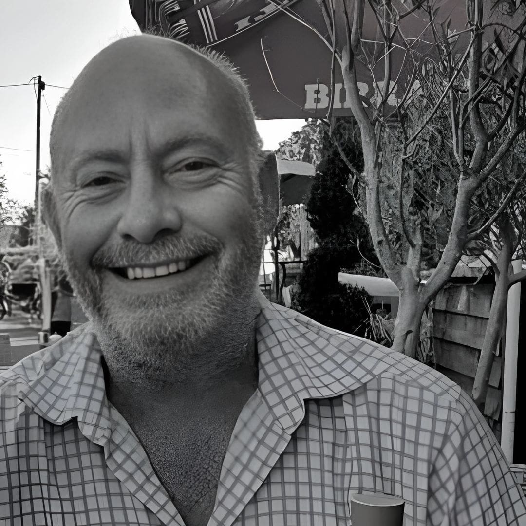 Black and white photo of Mark Pollak, owner of Billy Tong with a checkered shirt outdoors