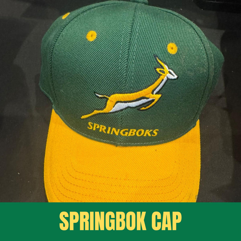 Green and yellow Springboks cap with a logo on a dark background