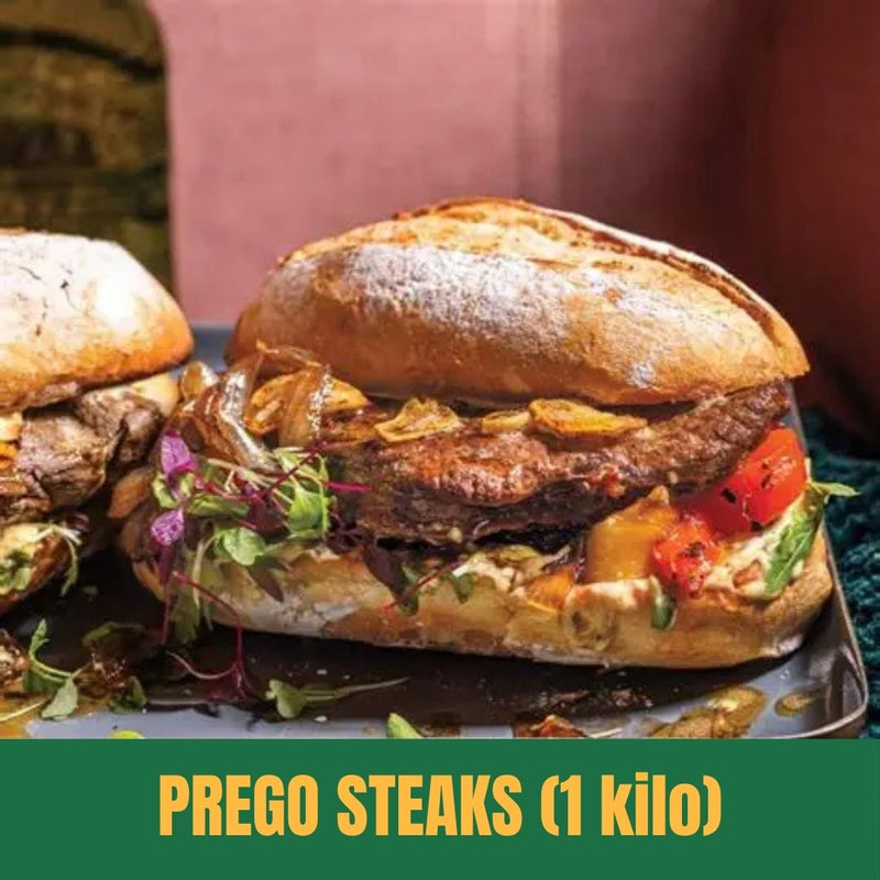 Two Prego Steaks sandwiches on a plate with a blurred background