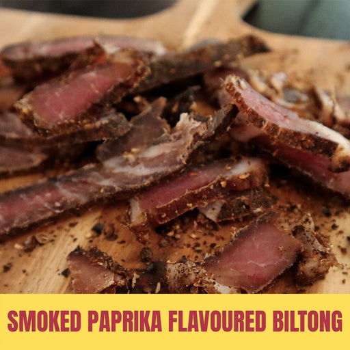 Sliced smoked paprika flavoured biltong on a wooden board with text overlay.