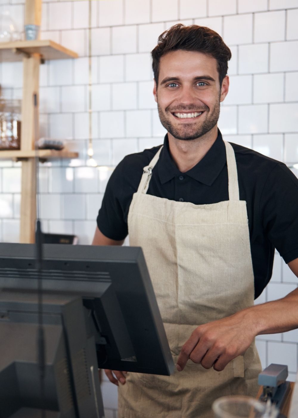 Man wearing an apron standing behind a counter in a kitchen setting. He is a wholesaler for Billy Tong Biltong products.